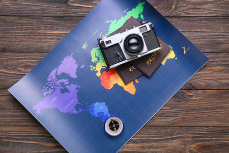 Photo camera, passports, compass and world map on wooden backgroundの写真素材