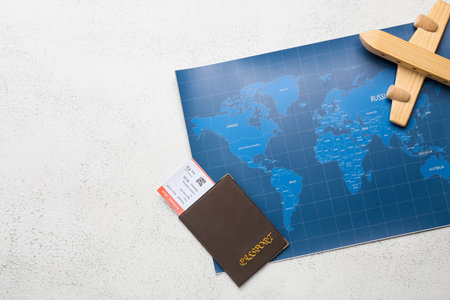 World map, wooden plane and passport with tickets on light background