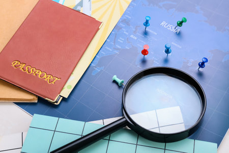Passport, magnifying glass and pins on world map, closeupの写真素材