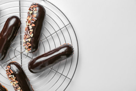 Grid with tasty chocolate eclairs on light backgroundの写真素材