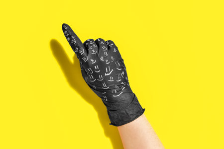 Hand in black medical glove with smile drawings pointing at something on color background