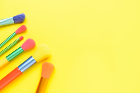Set of different makeup brushes on yellow backgroundの写真素材