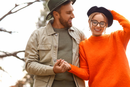 Happy fashionable couple on walk in autumn parkの写真素材
