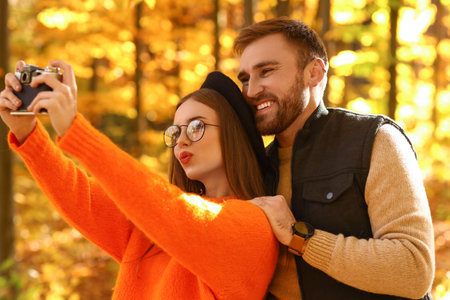 Young loving couple taking selfie in autumn parkの写真素材
