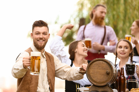 Man with beer celebrating Octoberfest outdoorsの写真素材
