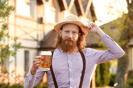 Bearded man with beer celebrating Octoberfest outdoorsの写真素材