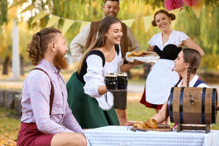 People with beer celebrating Octoberfest outdoorsの写真素材