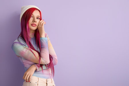 Beautiful young woman with bright hair on lilac background