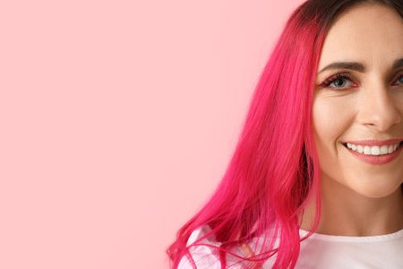 Beautiful woman with bright hair on pink backgroundの写真素材