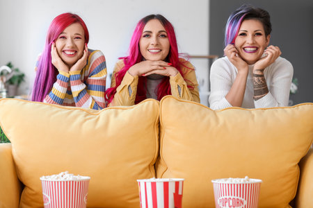 Beautiful women with popcorn watching movie at homeの写真素材