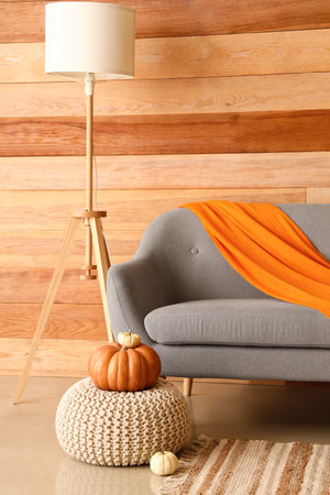 Comfortable sofa and modern lamp near wooden wallの写真素材