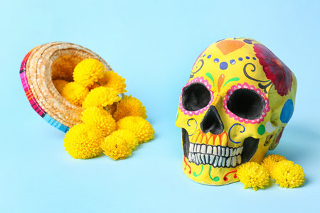 Painted human skull for Mexico's Day of the Dead (El Dia de Muertos) with sombrero and flowers on blue backgroundの写真素材
