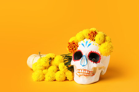 Painted human skull for Mexico's Day of the Dead (El Dia de Muertos) with pumpkin and flowers on...