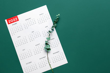 Classic calendar for 2022 year and eucalyptus branch on green backgroundの写真素材