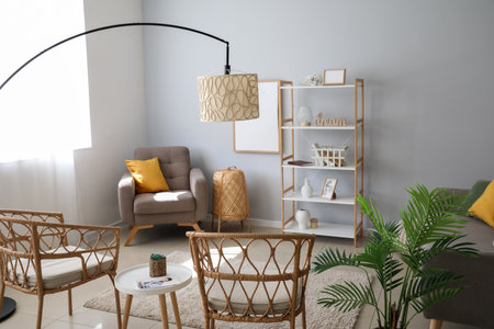 Interior of light living room with lamps, chairs and shelving unit