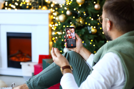 Young man during Christmas online party at homeの写真素材