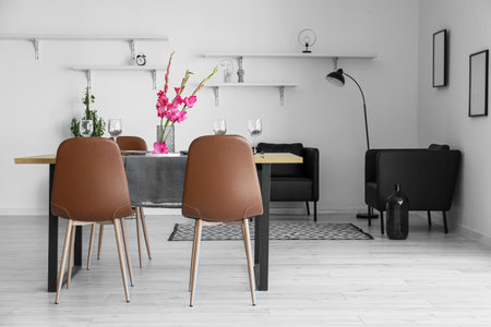 Stylish room interior with beautiful table setting and Gladiolus flowers