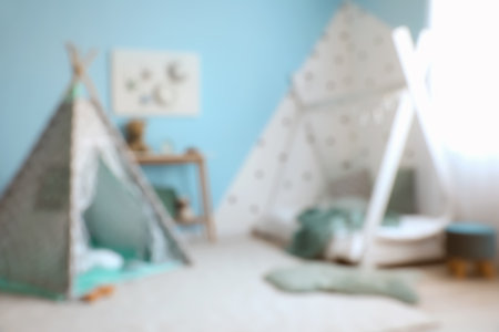 Blurred view of children's bedroom with play tent, table and pegboardの写真素材