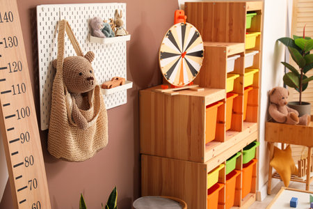 Pegboard with bag and toys hanging on color wall in children's playroomの写真素材