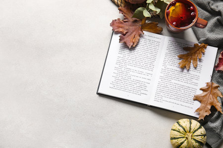 book, cup of tea and autumn decor on light backgroundの写真素材