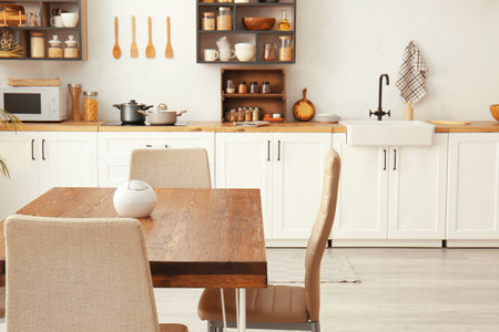 Wooden dining table with chairs in light kitchenの写真素材