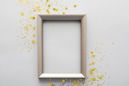 Composition with empty picture frame and golden sequins on gray backgroundの写真素材