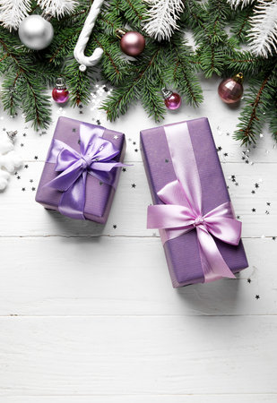 Composition with Christmas gifts, fir branches and decorations on light wooden backgroundの写真素材