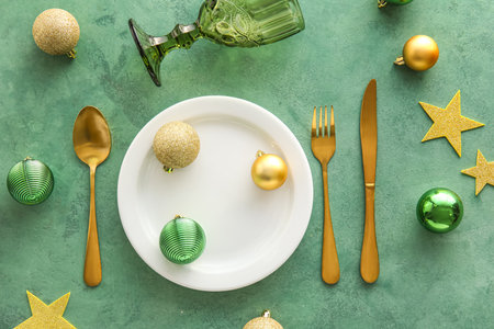 Beautiful table setting with Christmas decor on green backgroundの写真素材