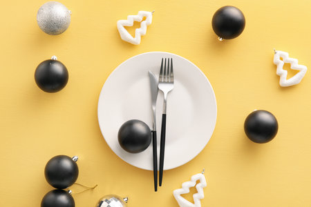 Beautiful table setting with Christmas decor on yellow backgroundの写真素材