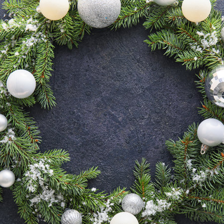 Christmas wreath decorated with balls and snow on dark backgroundの写真素材