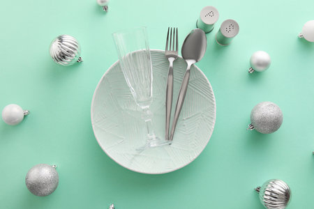 Beautiful table setting with Christmas balls on color backgroundの写真素材