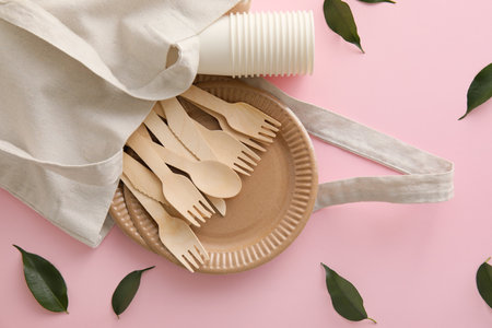 Tote bag with Eco tableware and plant leaves on pink backgroundの写真素材