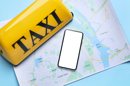 Yellow taxi roof sign, map and mobile phone on blue backgroundの写真素材