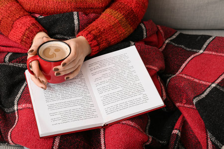 Woman with cup of coffee reading book, closeupの写真素材