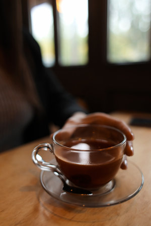 Woman drinking hot espresso at table in cafeの写真素材