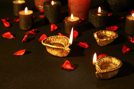 Diya lamps for Diwali, candles and flower petals on tableの写真素材