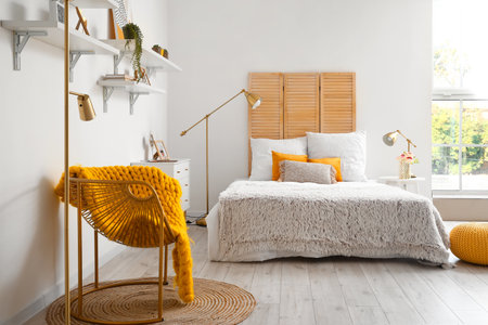 Interior of light bedroom with armchair and golden lampsの写真素材