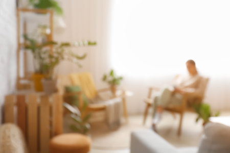 Woman reading book in modern living room, blurred viewの写真素材