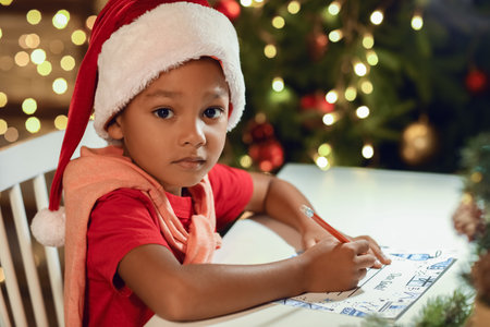 Cute African-American boy writing letter to Santa at homeの写真素材