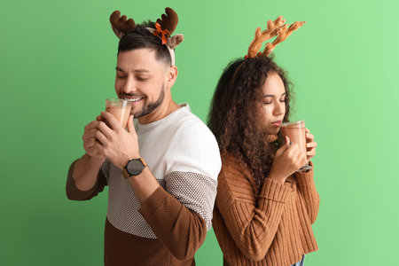 Happy couple with hot chocolate on color backgroundの写真素材