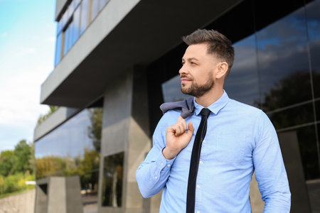 Handsome businessman near office buildingの写真素材