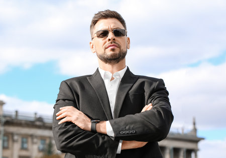 Stylish businessman in sunglasses on city squareの写真素材