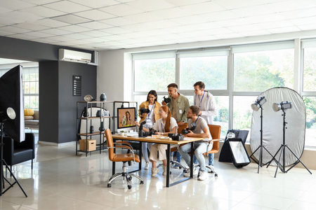 Professional photographer teaching young people in studioの写真素材