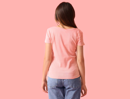 Young woman in blank t-shirt on color background, back view