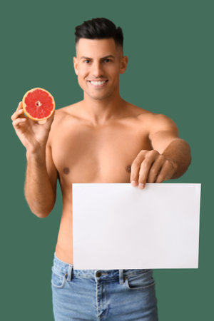 Young man with grapefruit and blank poster on color background. Vegan Dayの写真素材