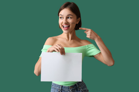 Young woman with blank poster on color background. Vegan Dayの写真素材