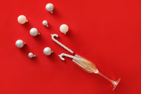 Composition with glass and Christmas decorations on red backgroundの写真素材