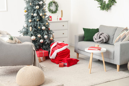 Stylish interior of modern living room with beautiful Christmas tree, Santa bags and giftsの写真素材