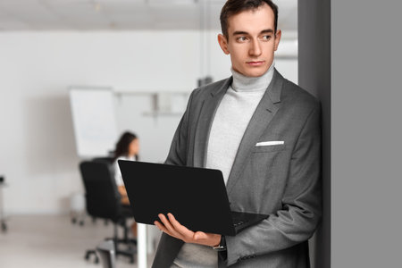 Young businessman with laptop during meeting in office