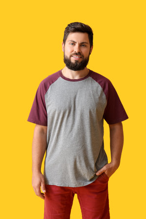 Handsome man in t-shirt on yellow backgroundの写真素材